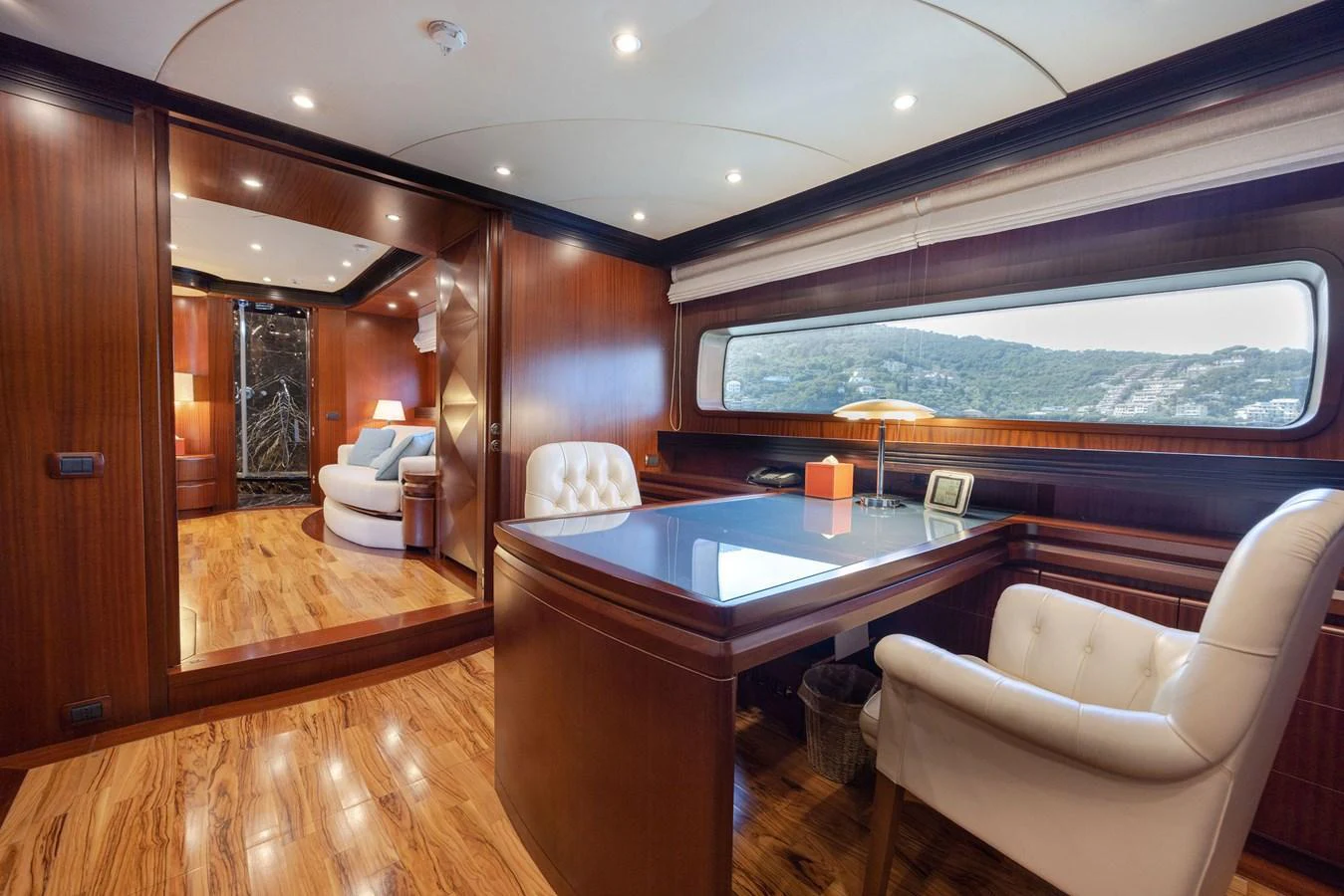 The yacht's office features elegant wood paneling and a large window with a scenic view. aboard HOLIDAY Yacht for Sale
