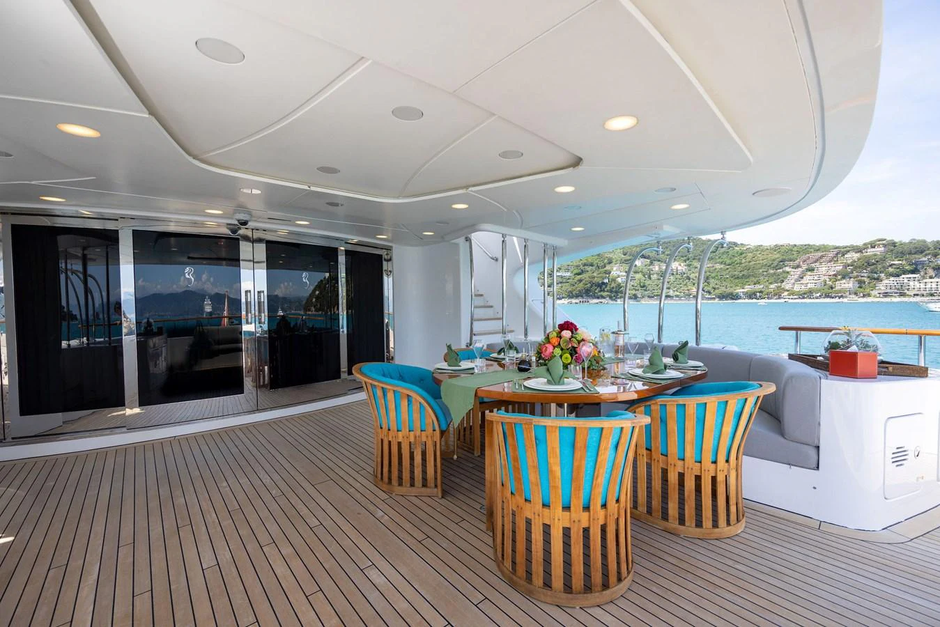 The aft deck features a spacious dining area with elegant seating and a beautiful view of the water. aboard HOLIDAY Yacht for Sale