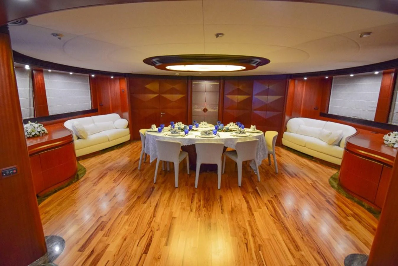 The yacht's dining area features a luxurious setting with a large round table and elegant seating. aboard HOLIDAY Yacht for Sale