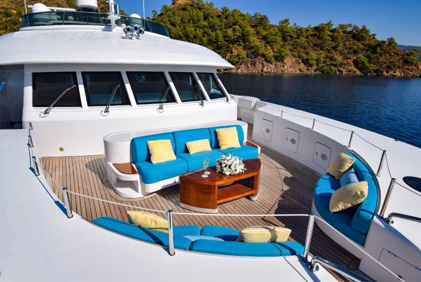 The foredeck features a stylish seating area with vibrant blue cushions, perfect for relaxation and socializing. aboard HOLIDAY Yacht for Sale