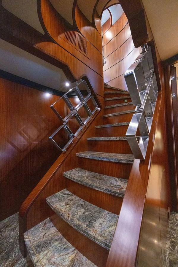 A luxurious staircase with polished wood and marble steps leads to the upper deck. aboard HOLIDAY Yacht for Sale