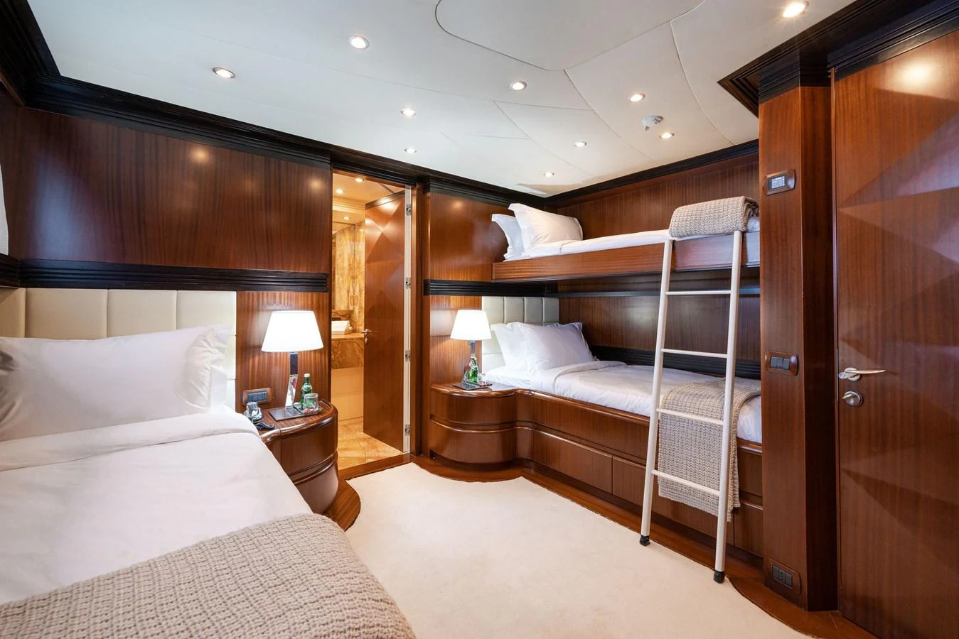 A cozy guest stateroom featuring bunk beds and elegant wooden finishes. aboard HOLIDAY Yacht for Sale
