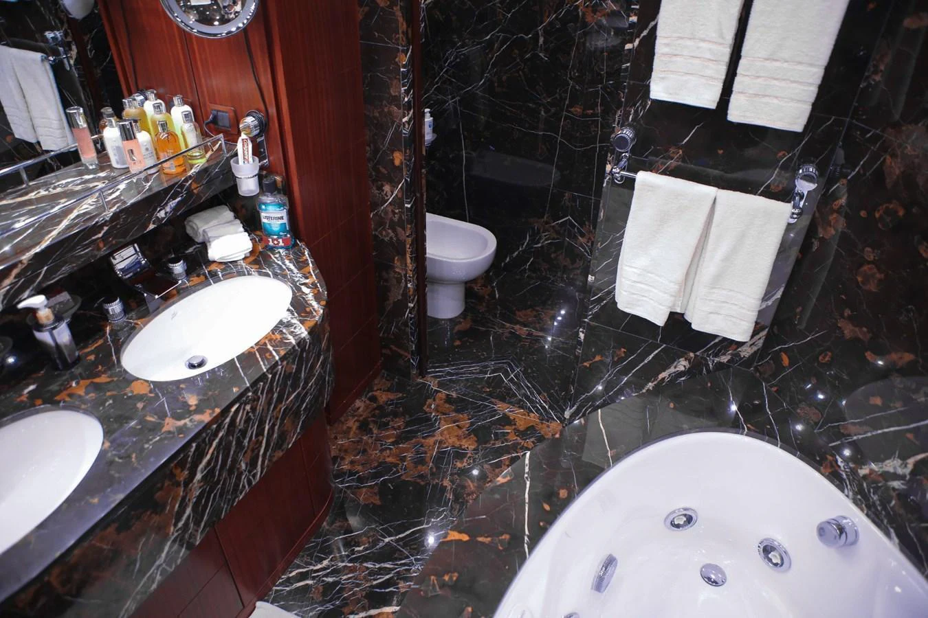 The luxurious bathroom features a marble countertop, dual sinks, and a jacuzzi tub. aboard HOLIDAY Yacht for Sale