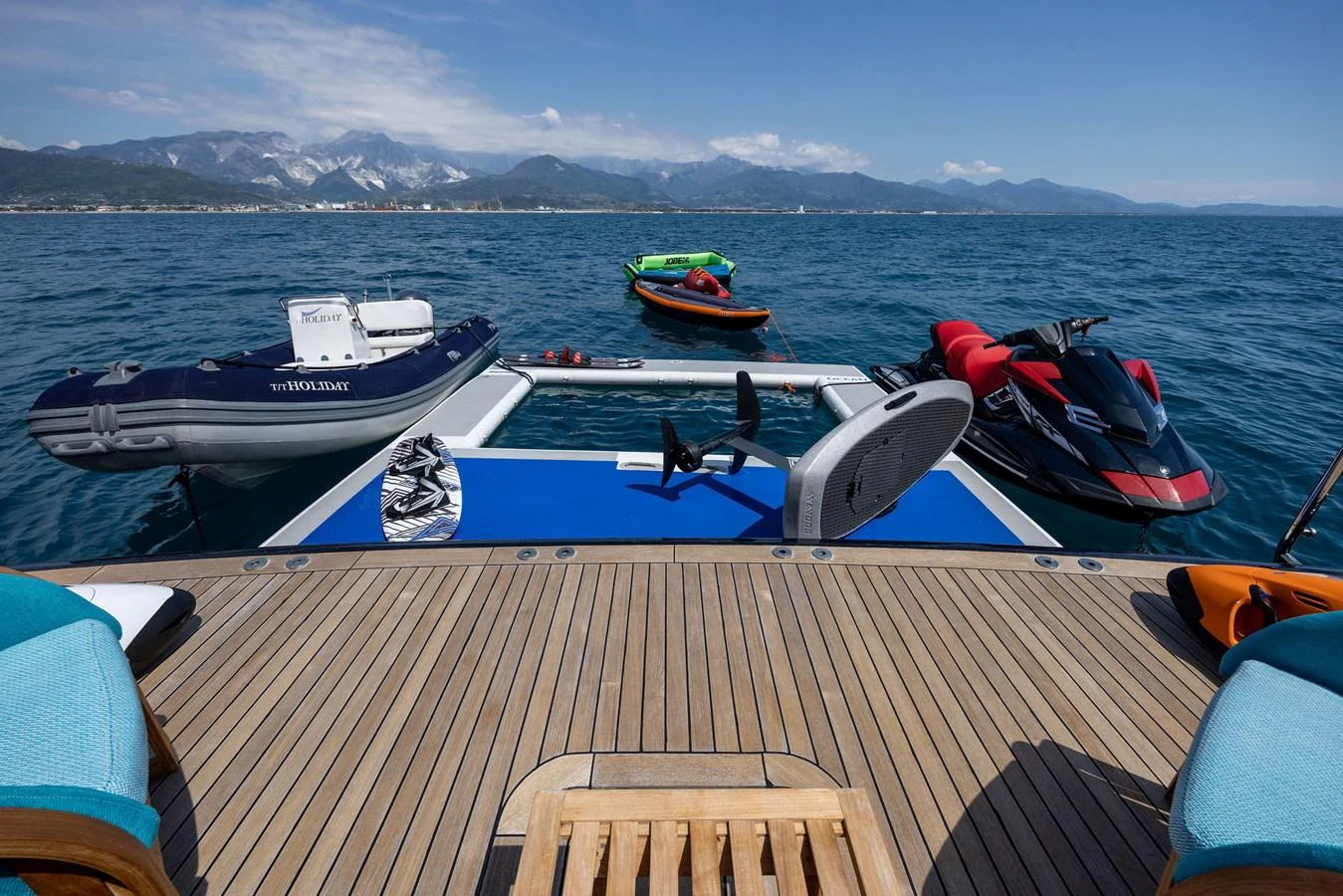 The yacht's swim platform is equipped with various water toys, including jet skis and inflatable boats, perfect for aquatic adventures. aboard HOLIDAY Yacht for Sale