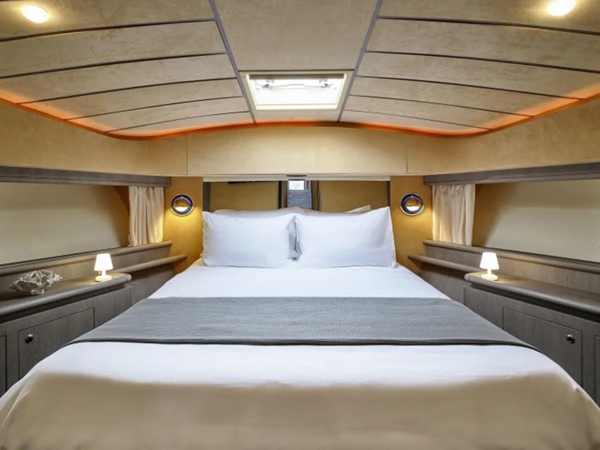 a bed with a white pillow aboard MIREN Yacht for Sale