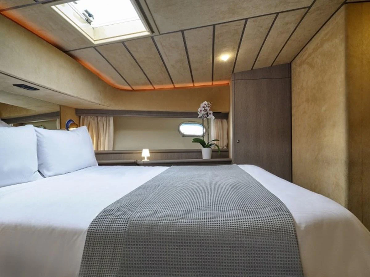 a bed with white sheets aboard MIREN Yacht for Sale