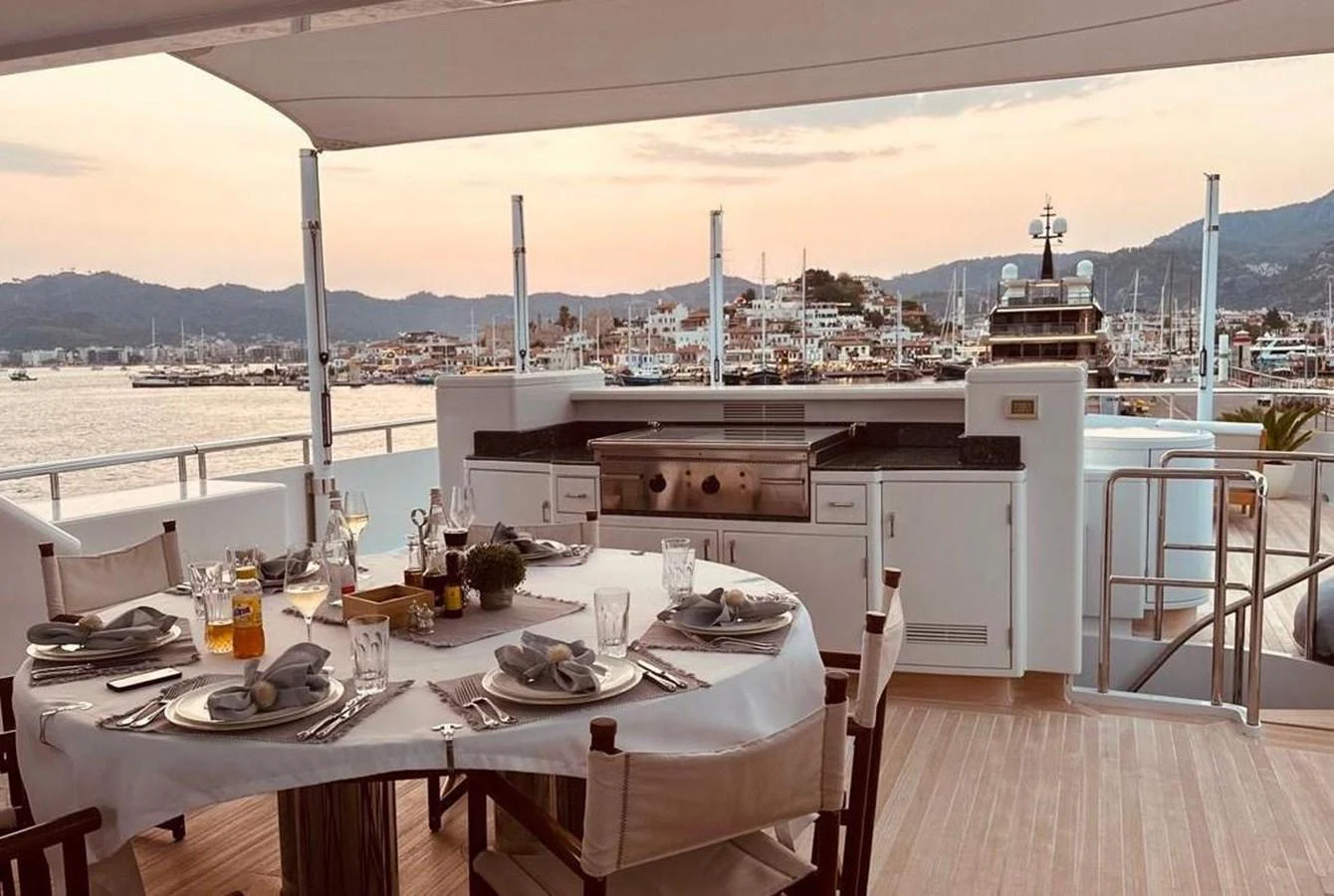 The yacht features a charming alfresco dining area with a scenic view of the marina. aboard PRINCESS TOO Yacht for Sale