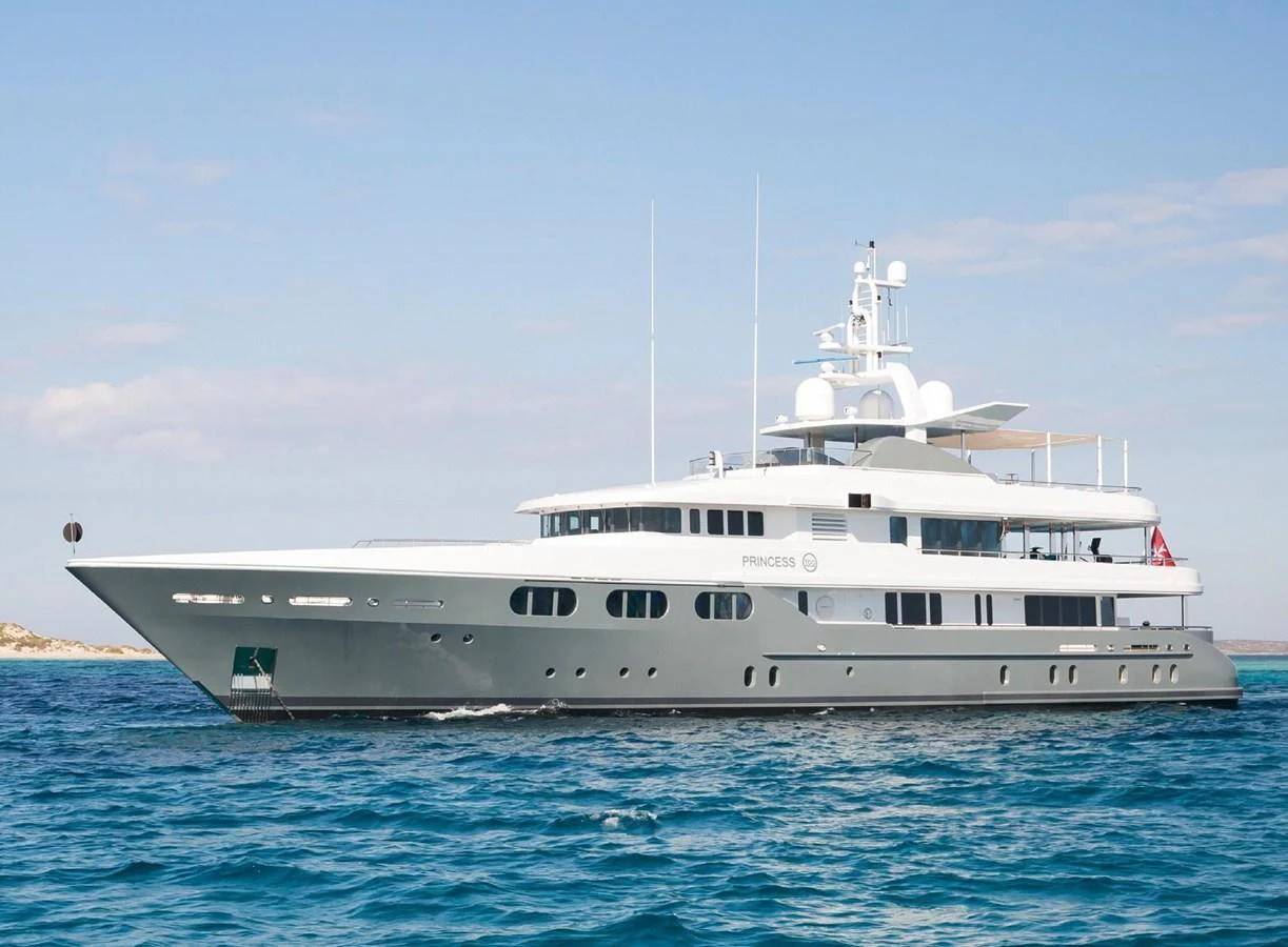 A sleek and modern yacht glides gracefully on the open water under a clear blue sky. aboard PRINCESS TOO Yacht for Sale