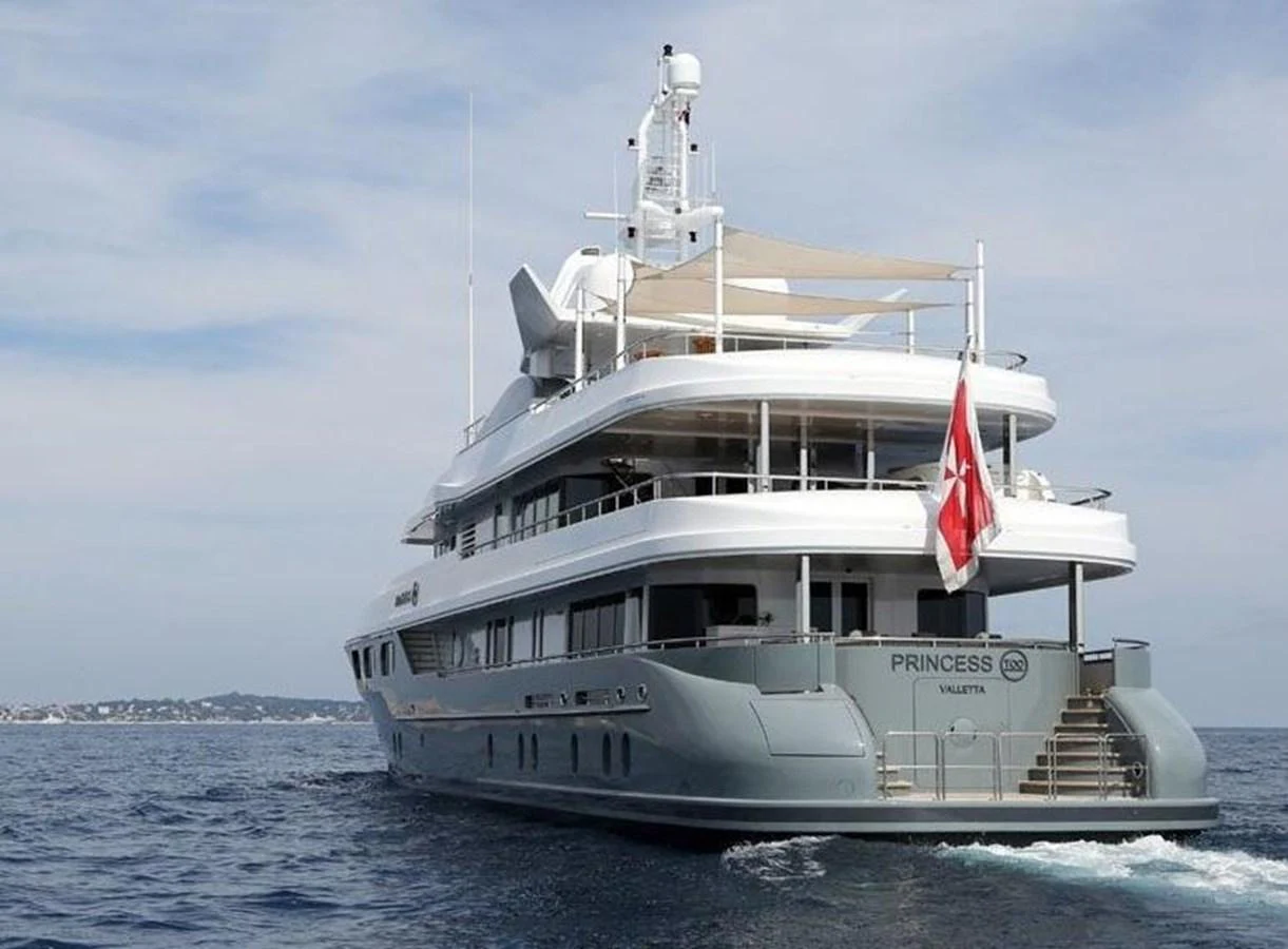 A luxurious yacht cruising on calm waters with a clear sky backdrop. aboard PRINCESS TOO Yacht for Sale
