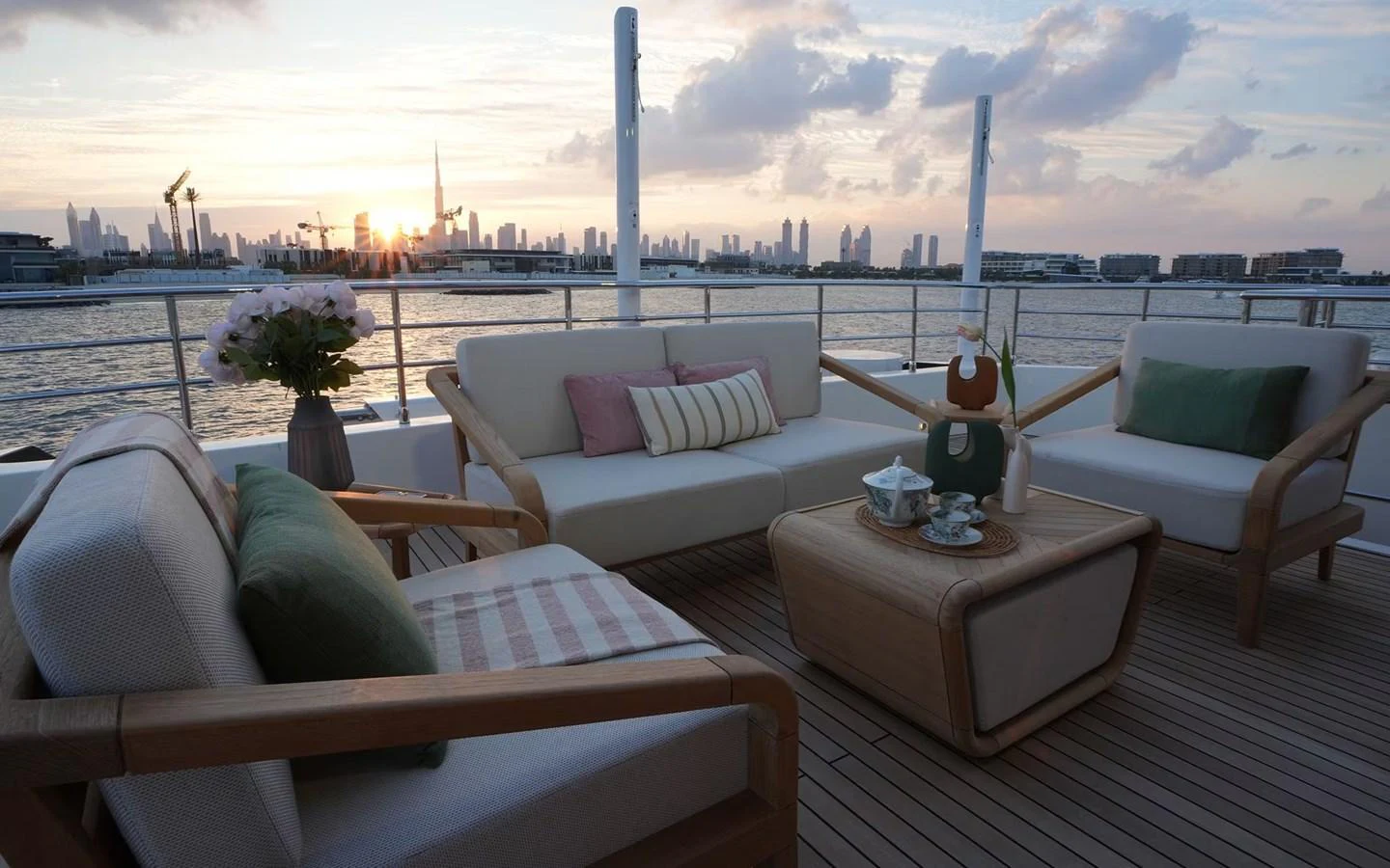 The aft deck features comfortable seating with a stunning cityscape view at sunset. aboard GEULUNEL Yacht for Sale