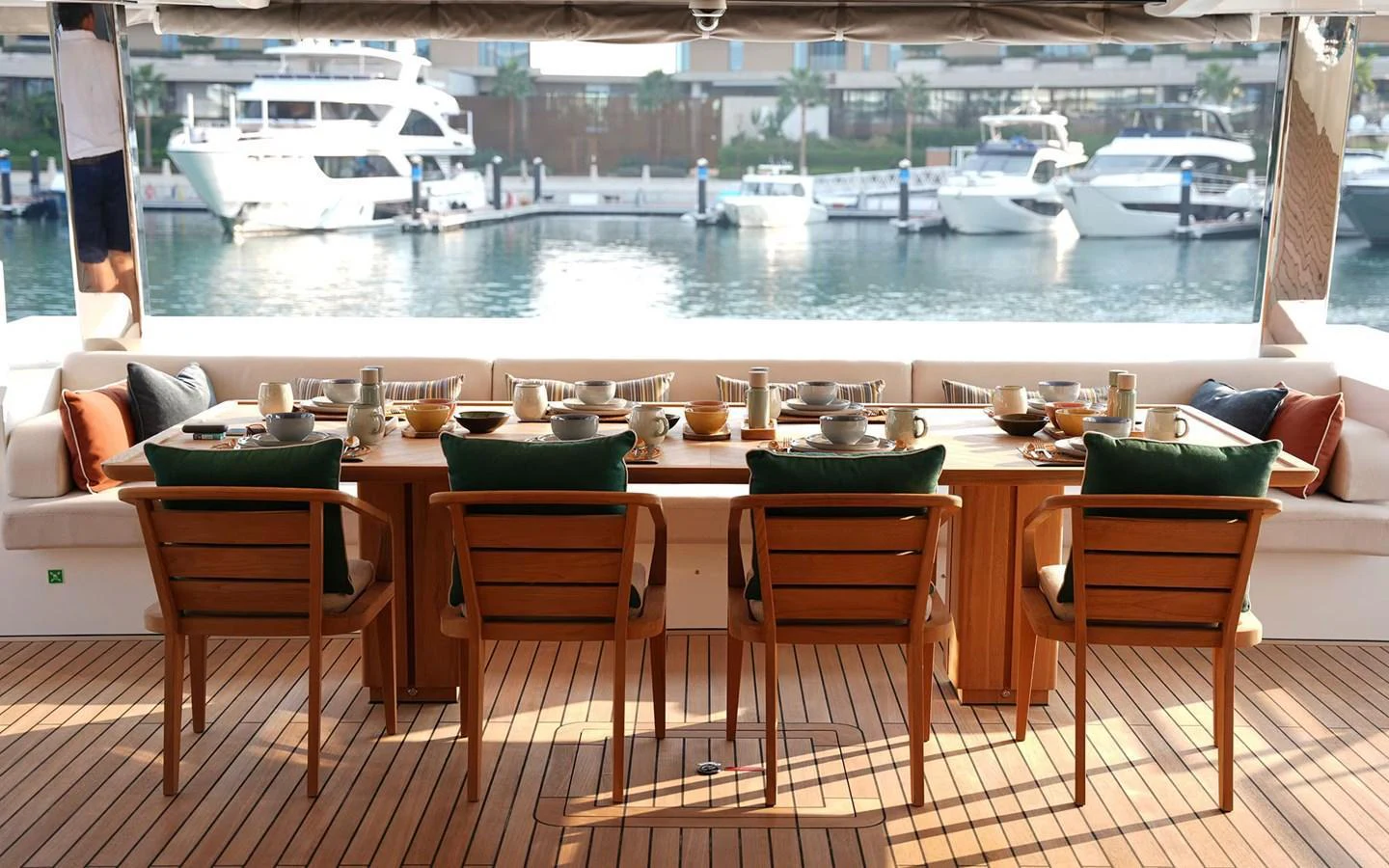 The aft deck features a beautifully set dining table with a view of the marina. aboard GEULUNEL Yacht for Sale