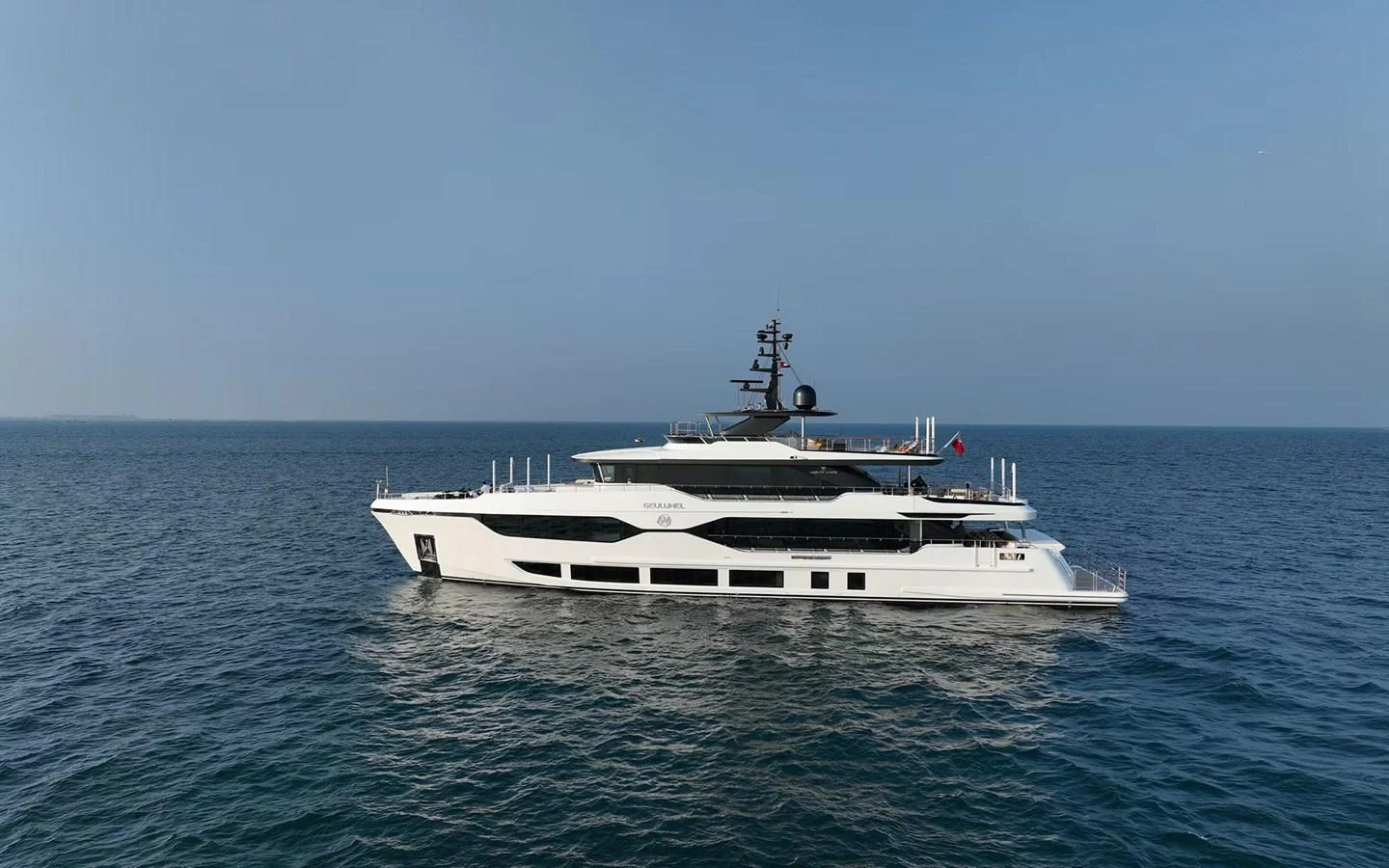A sleek and modern yacht cruising on calm waters under a clear sky. aboard GEULUNEL Yacht for Sale