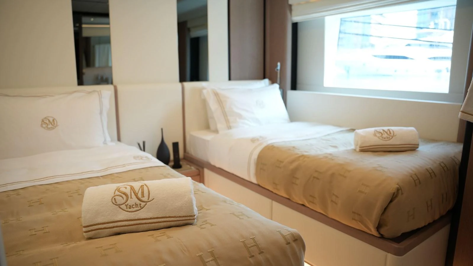 The guest stateroom features twin beds with luxurious linens and a large window for natural light. aboard GEULUNEL Yacht for Sale
