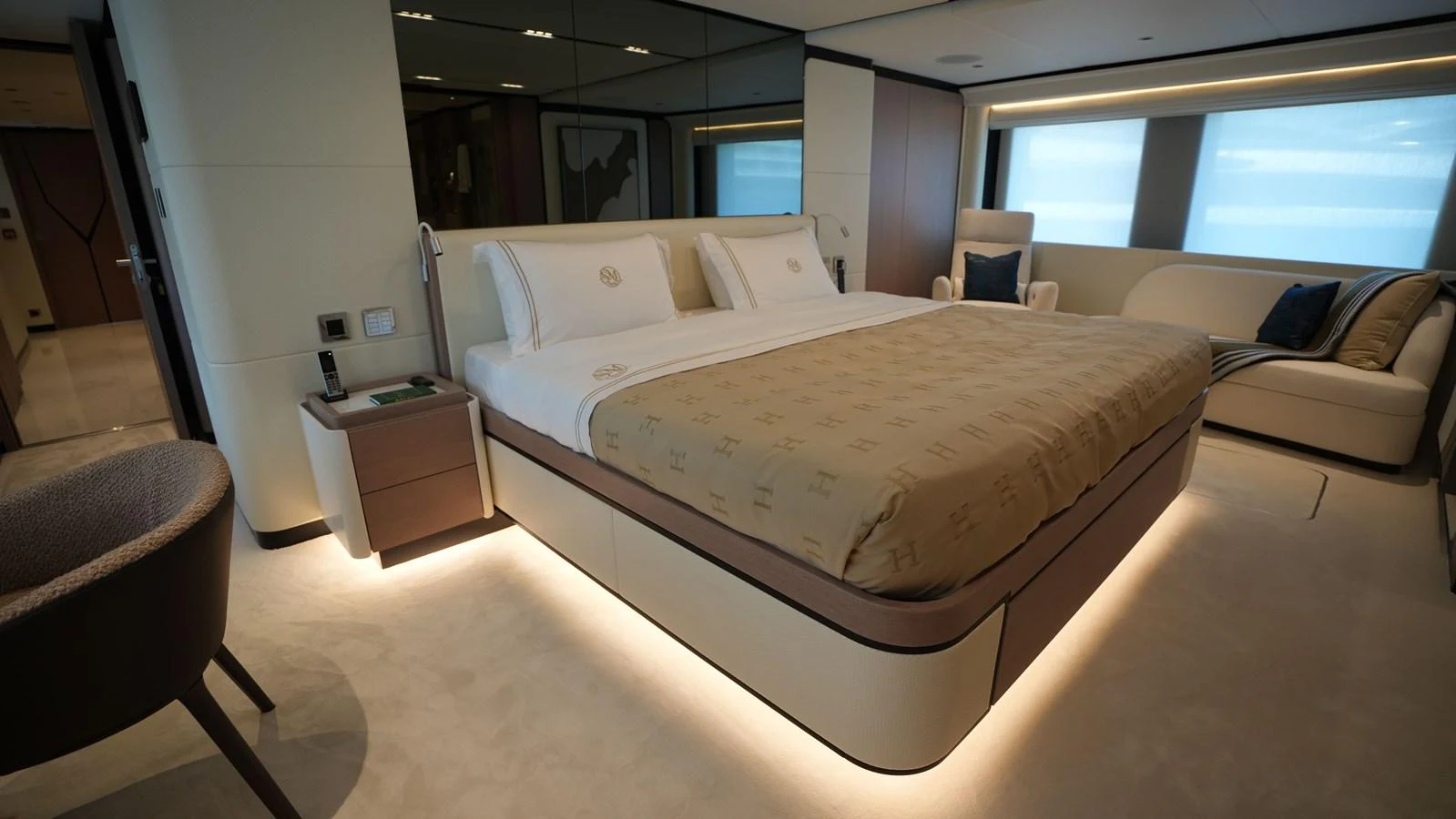 The master stateroom features a luxurious bed with elegant bedding and ambient lighting. aboard GEULUNEL Yacht for Sale