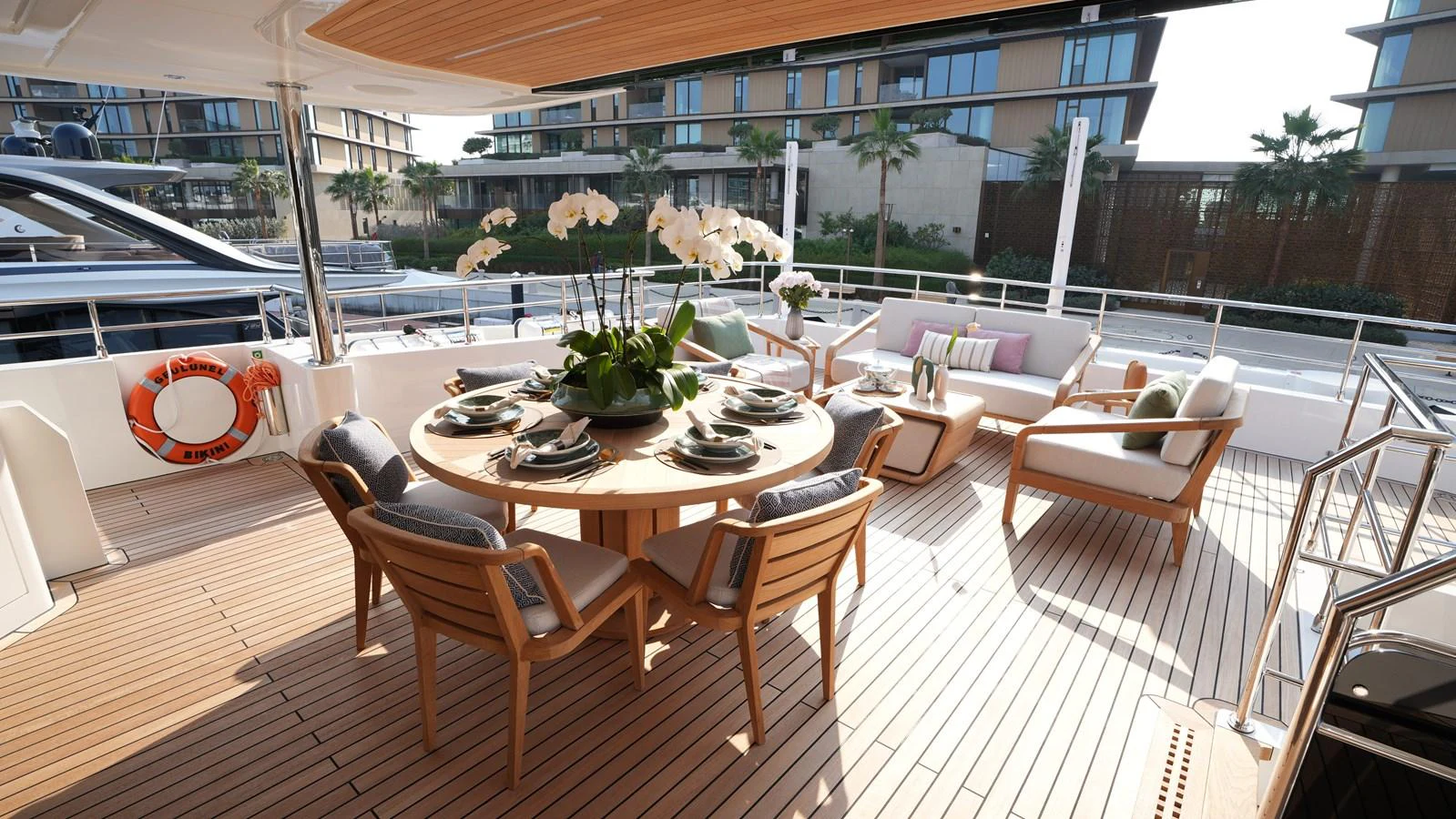 The aft deck features an elegant dining area with a round table and comfortable seating, perfect for alfresco meals. aboard GEULUNEL Yacht for Sale