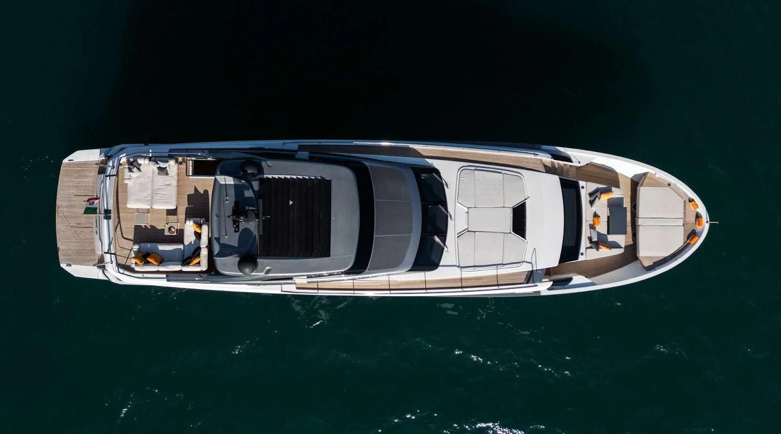 A sleek yacht is captured from above, showcasing its spacious deck and elegant design. aboard SOLEDO Yacht for Sale