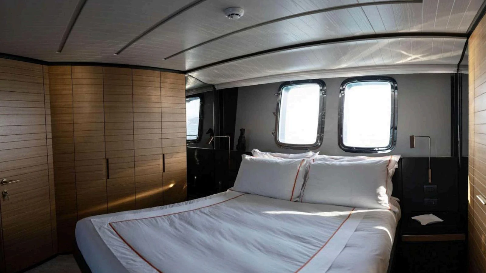 The stateroom features a luxurious bed with ample natural light from the windows. aboard SOLEDO Yacht for Sale