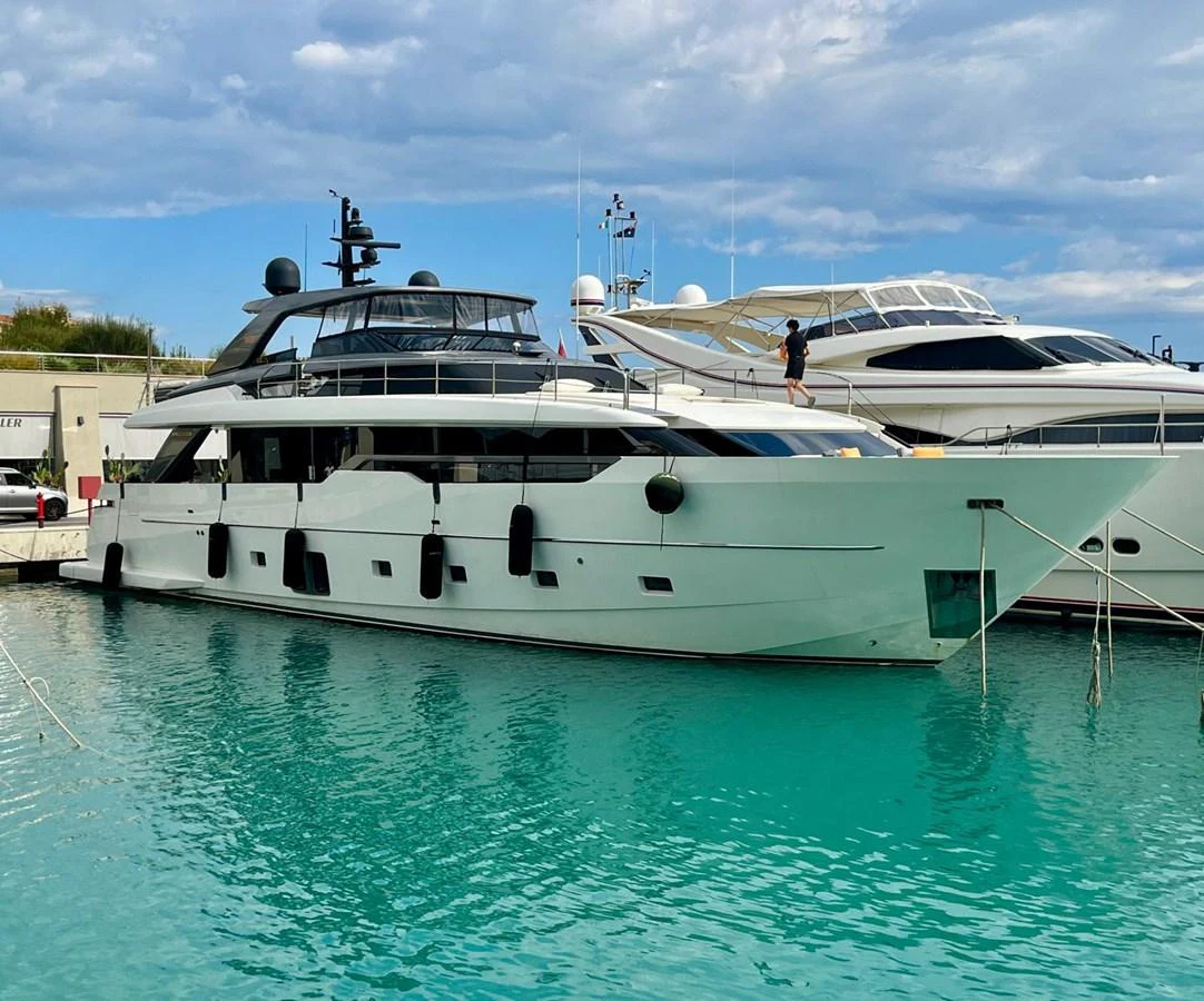 A sleek and modern yacht is docked in a serene marina, showcasing its elegant design and spacious decks. aboard SOLEDO Yacht for Sale