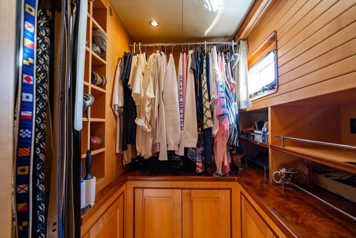 a closet with clothes on the wall aboard NEVER BETTER Yacht for Sale
