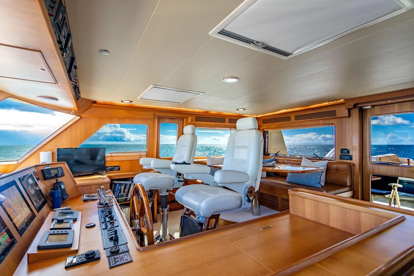 inside of a building with a large window and a large table with chairs and a laptop on it aboard NEVER BETTER Yacht for Sale