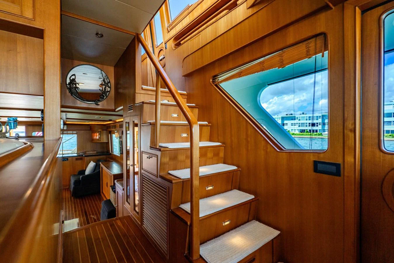 a room with a wood staircase and a wood floor and a round mirror aboard NEVER BETTER Yacht for Sale