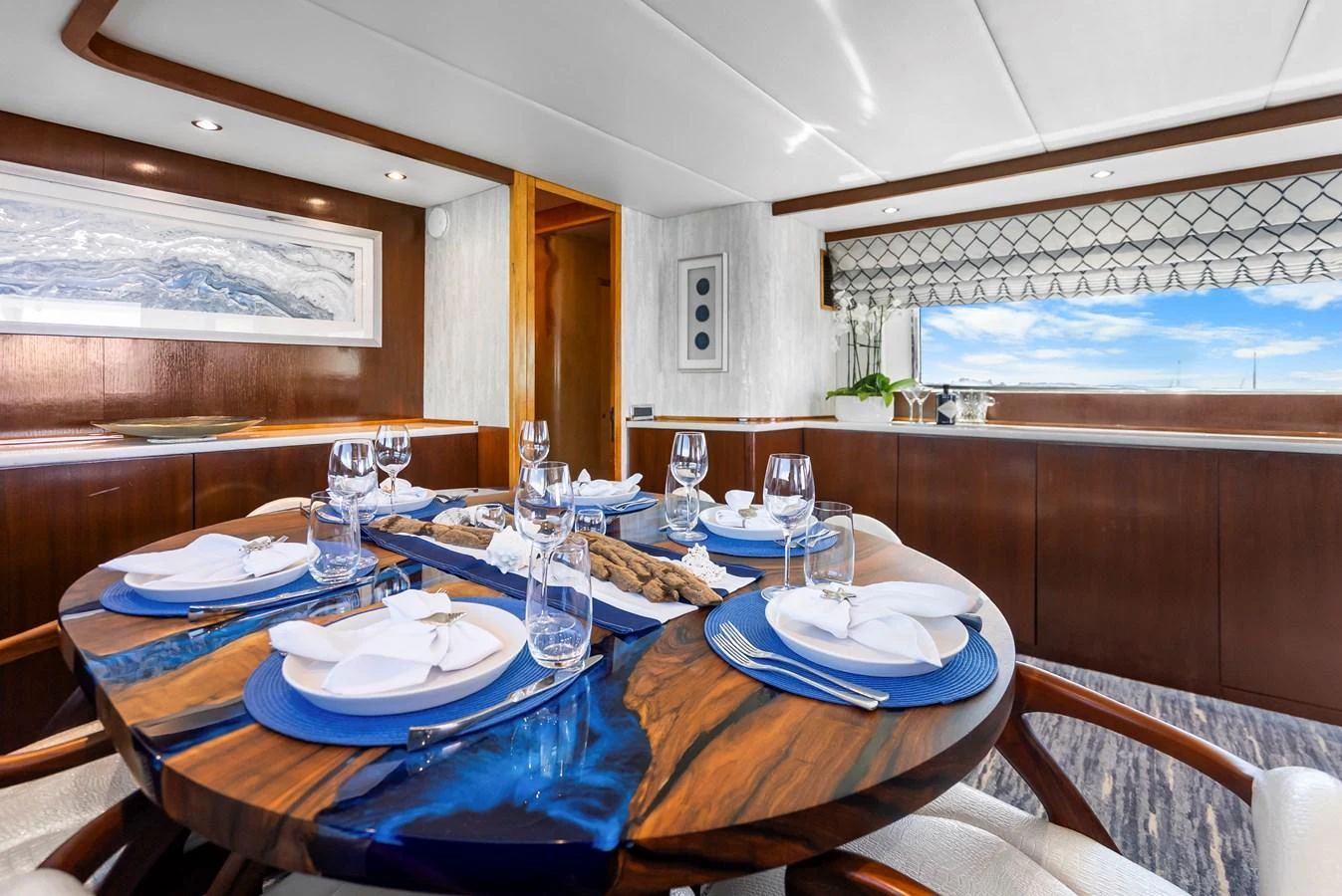 a dining table with plates and glasses aboard AZURE Yacht for Sale
