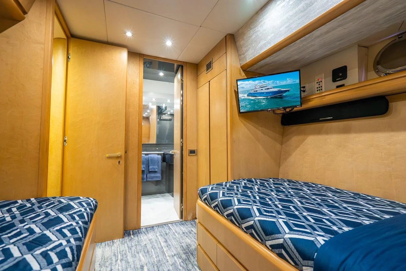 a room with a bed and a tv on the wall aboard AZURE Yacht for Sale