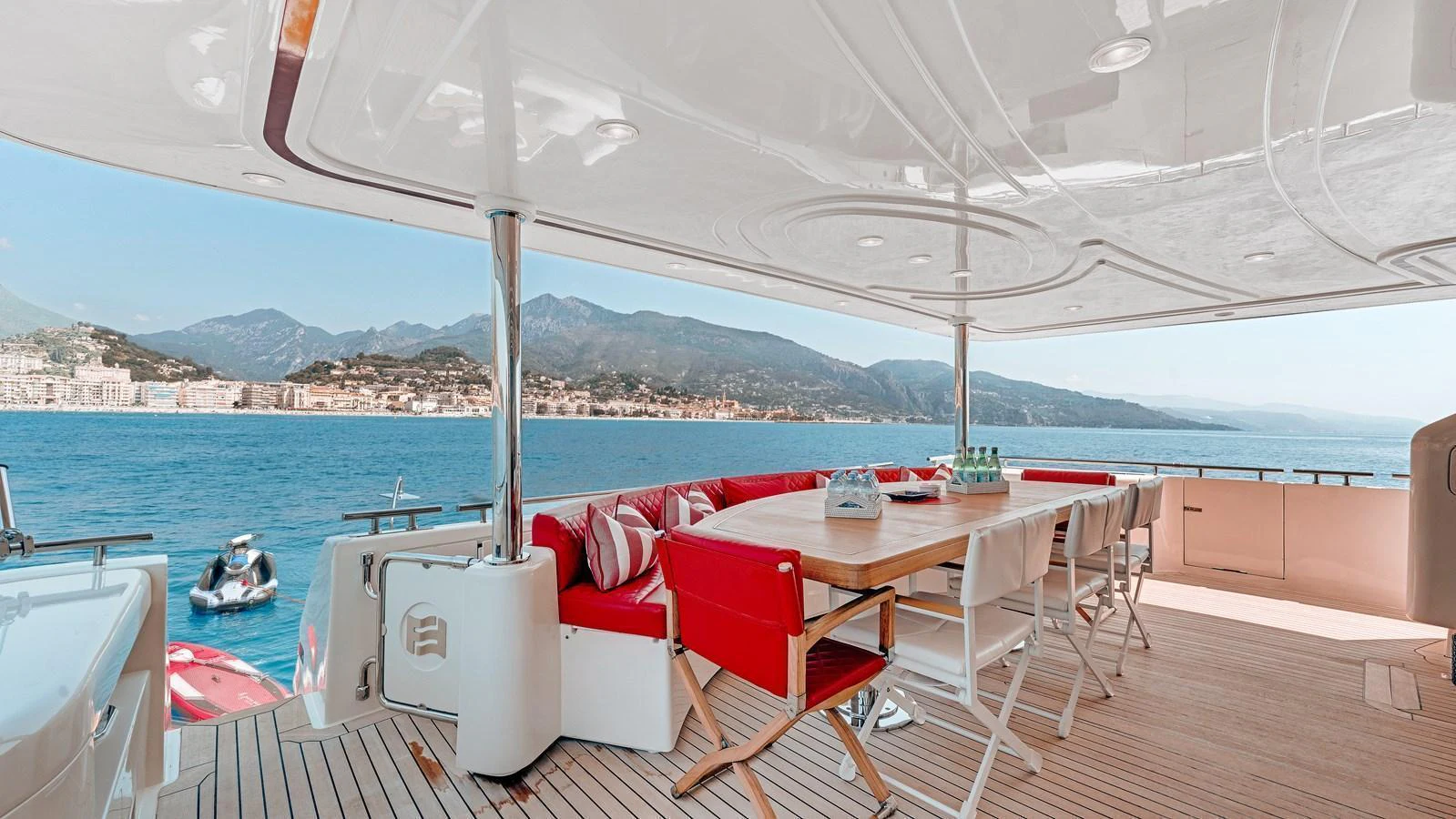 The aft deck offers a spacious and inviting area with comfortable seating and a dining table, perfect for enjoying the scenic views. aboard CHAMPAGNE AND CAVIAR Yacht for Sale