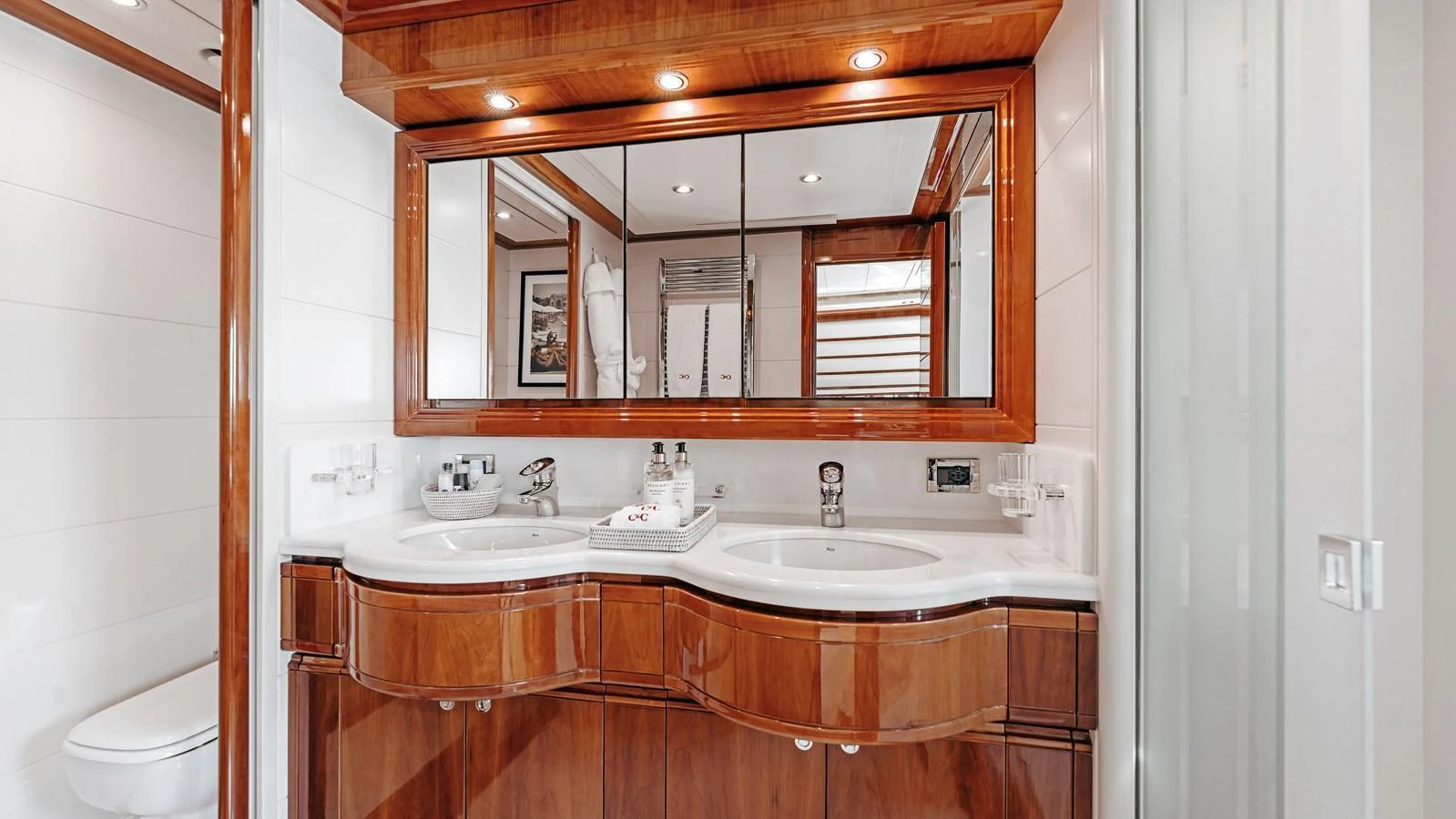 The yacht's bathroom features elegant wood finishes and dual sinks, creating a luxurious and functional space. aboard CHAMPAGNE AND CAVIAR Yacht for Sale