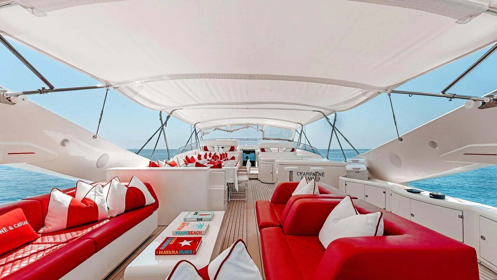 The sundeck features luxurious red and white seating under a large canopy, perfect for relaxation and entertainment. aboard CHAMPAGNE AND CAVIAR Yacht for Sale