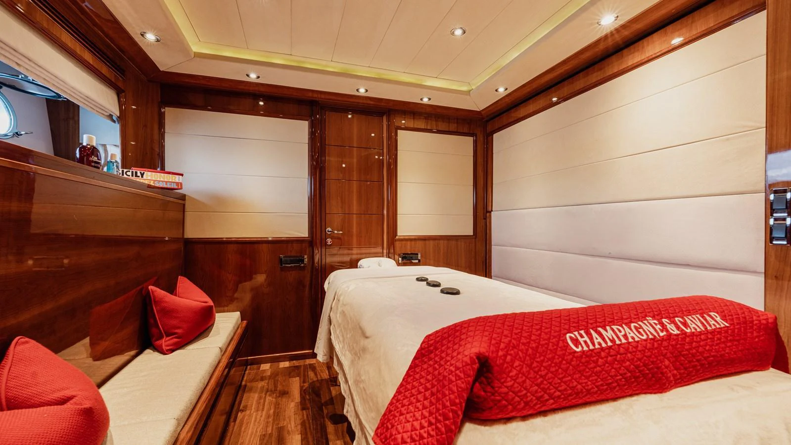 A luxurious spa room with a massage table and elegant wooden finishes. aboard CHAMPAGNE AND CAVIAR Yacht for Sale