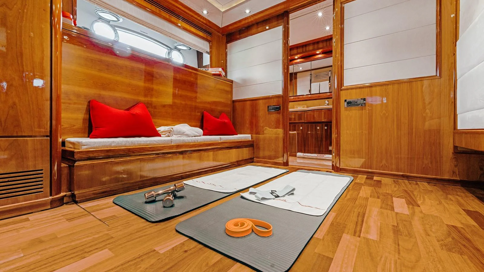 The yacht's interior gym features wooden paneling and modern fitness equipment for a luxurious workout experience. aboard CHAMPAGNE AND CAVIAR Yacht for Sale