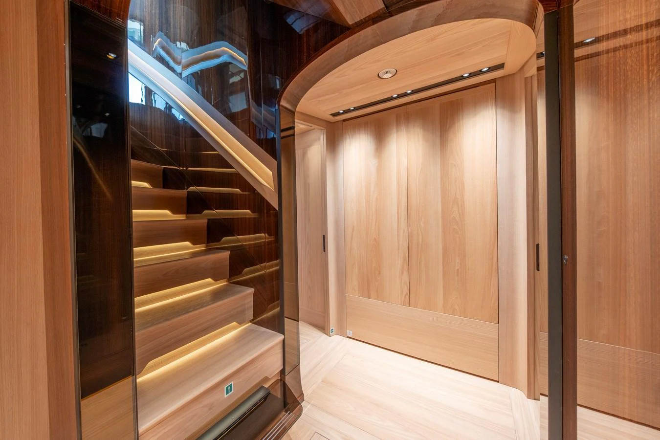The yacht's interior features a beautifully designed staircase with warm wooden finishes and modern lighting. aboard ANNABELLA Yacht for Sale