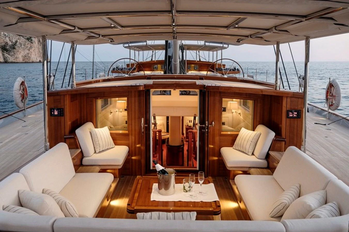 The aft deck features a cozy seating area with plush cushions and a central table, perfect for relaxing and enjoying the view. aboard APSARA Yacht for Sale