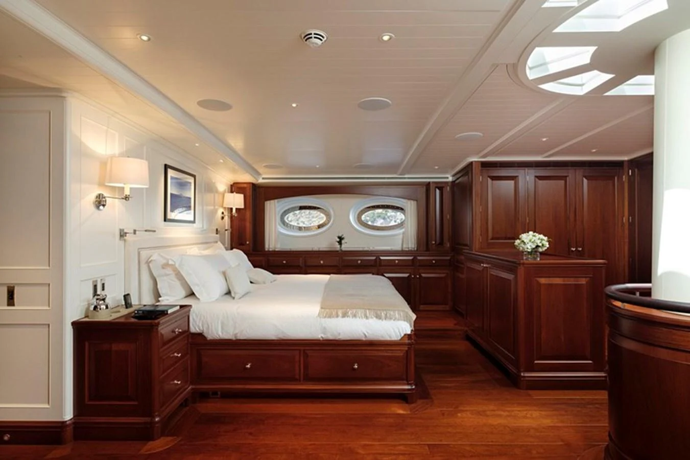 The master stateroom features elegant wood paneling and luxurious bedding, creating a serene and sophisticated retreat. aboard APSARA Yacht for Sale