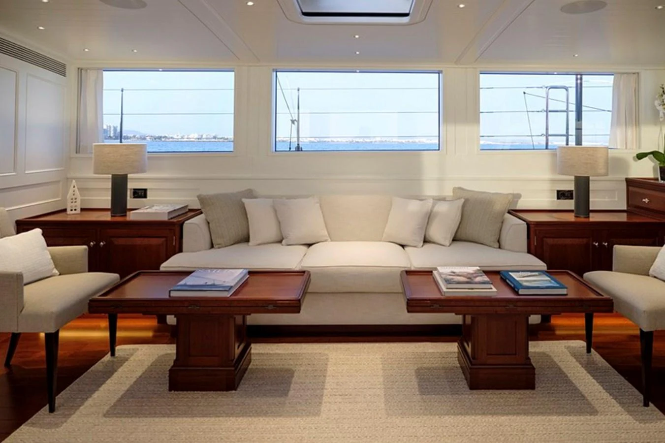The salon features elegant seating with large windows offering stunning sea views. aboard APSARA Yacht for Sale