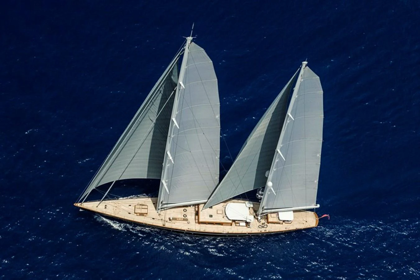 A stunning sailing yacht glides gracefully over deep blue waters, showcasing its elegant design and impressive sails. aboard APSARA Yacht for Sale