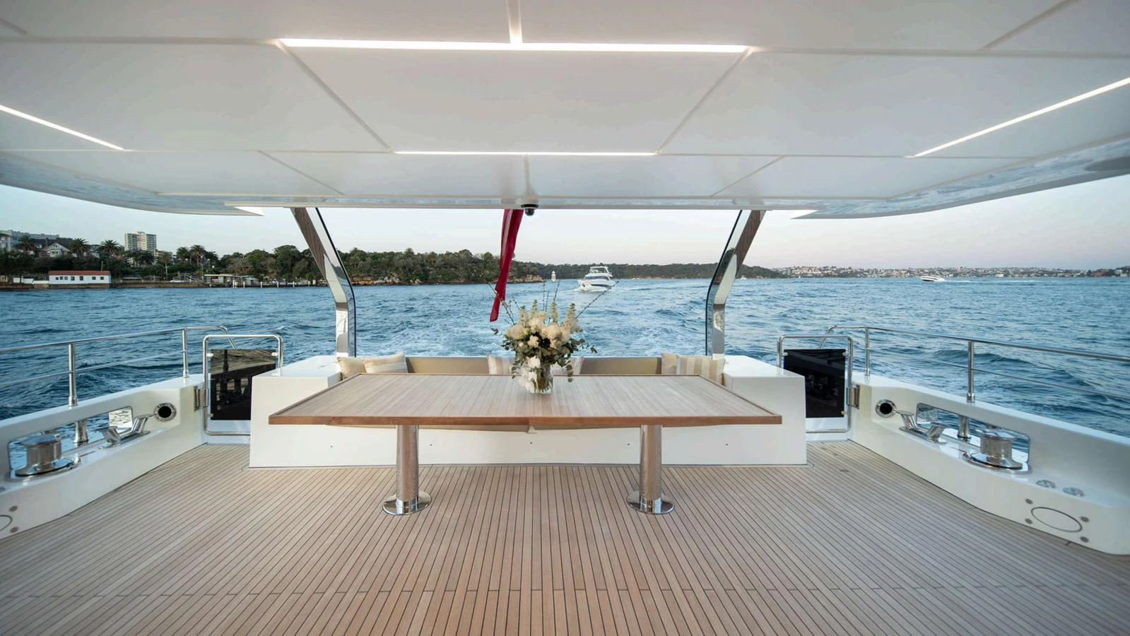 The aft deck features a spacious and elegant dining area with a beautiful view of the water. aboard NOMAD 101 ON-ORDER Yacht for Sale