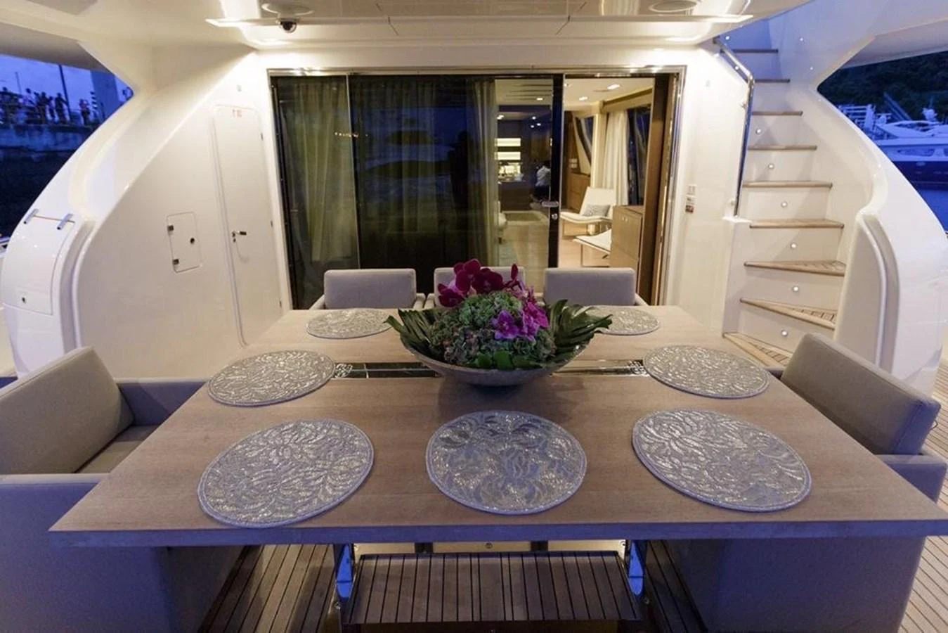 The aft deck features an elegant dining area with a beautifully set table and comfortable seating. aboard SHA SHA SHA IV Yacht for Sale