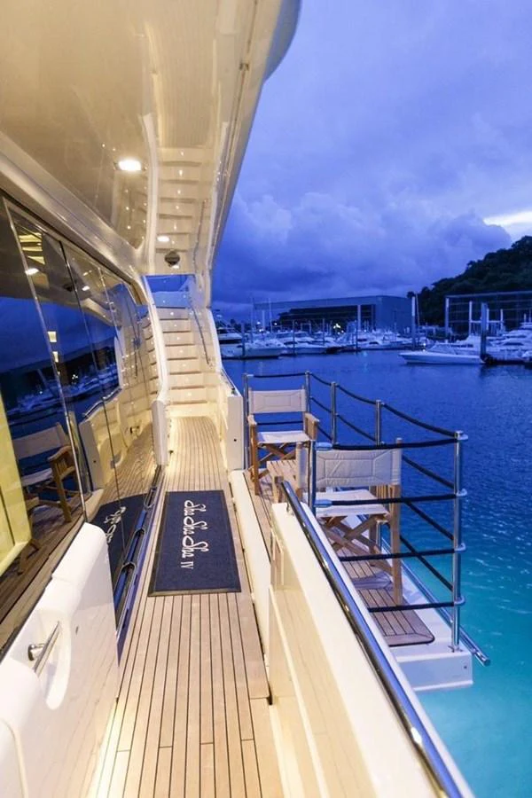 The yacht's side deck offers a serene view of the marina with comfortable seating and elegant design. aboard SHA SHA SHA IV Yacht for Sale