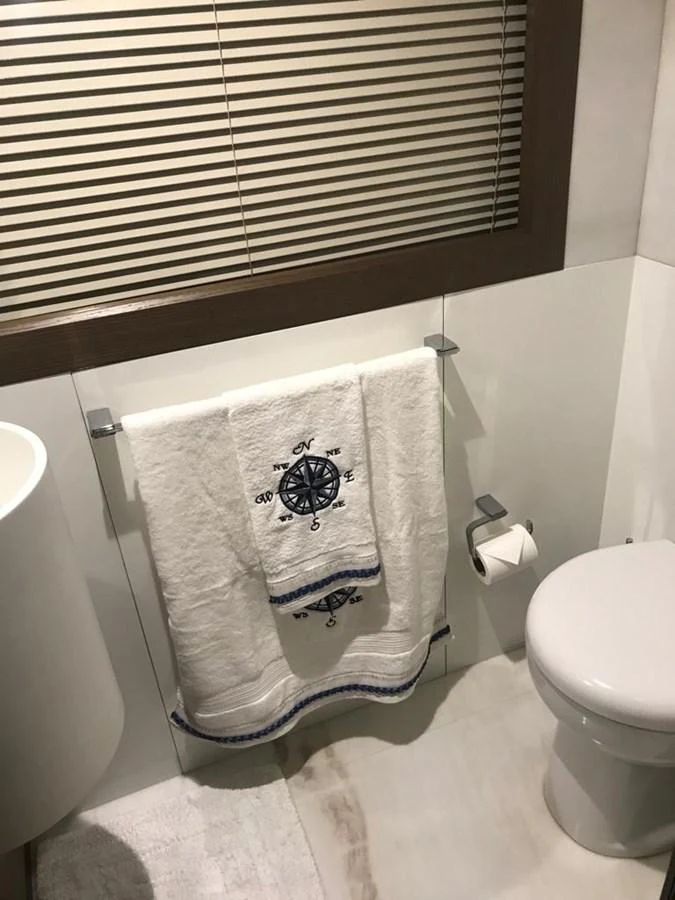 A well-appointed yacht bathroom with a nautical-themed towel and modern fixtures. aboard SHA SHA SHA IV Yacht for Sale