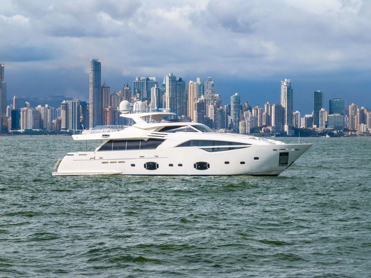 A sleek and modern yacht cruises against a backdrop of a bustling city skyline. aboard SHA SHA SHA IV Yacht for Sale