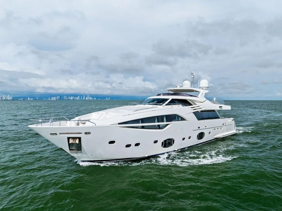 A sleek and modern yacht cruises through open waters under a cloudy sky. aboard SHA SHA SHA IV Yacht for Sale