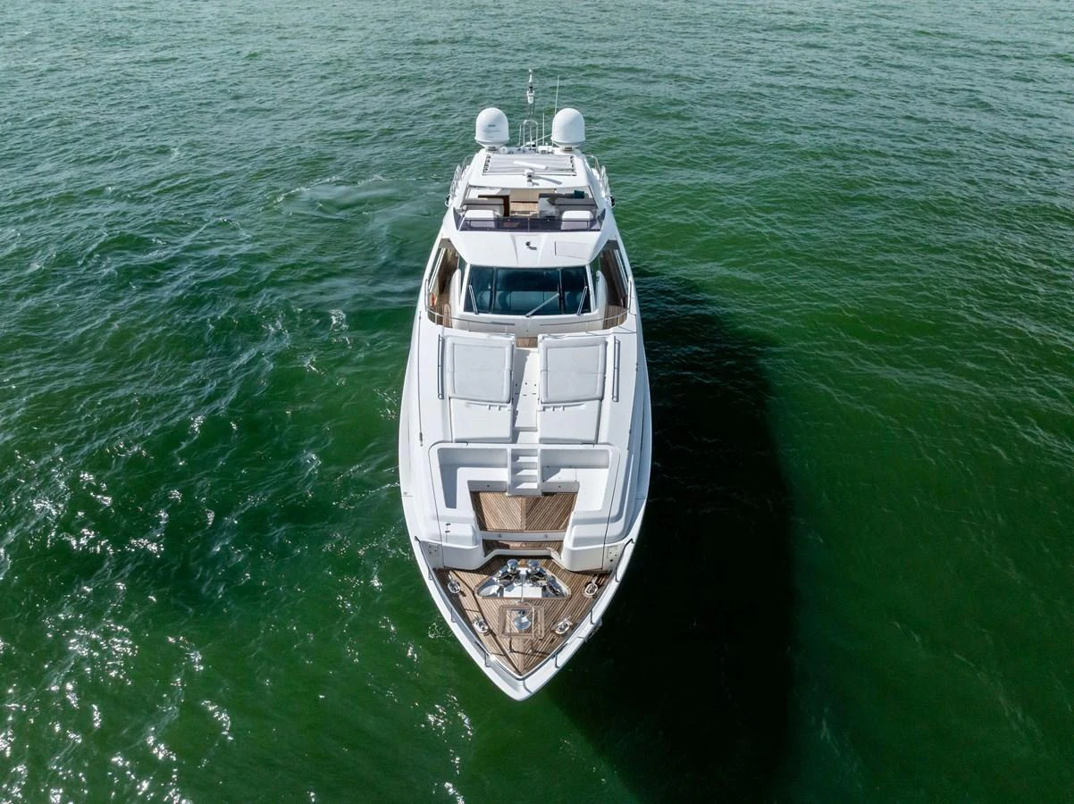 A sleek and modern yacht glides gracefully on calm green waters, showcasing its elegant design from an aerial perspective. aboard SHA SHA SHA IV Yacht for Sale