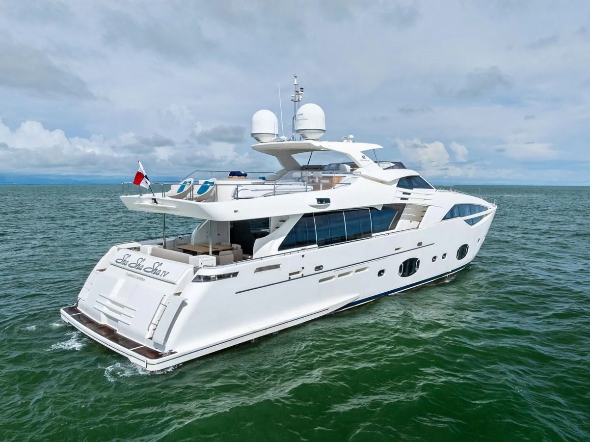 A sleek and modern yacht glides gracefully on calm waters under a clear sky. aboard SHA SHA SHA IV Yacht for Sale
