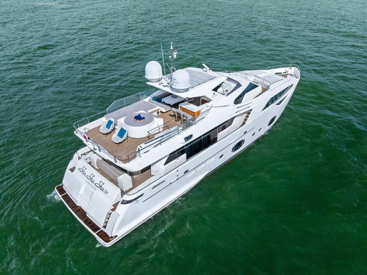 A sleek and modern yacht cruising on calm green waters. aboard SHA SHA SHA IV Yacht for Sale