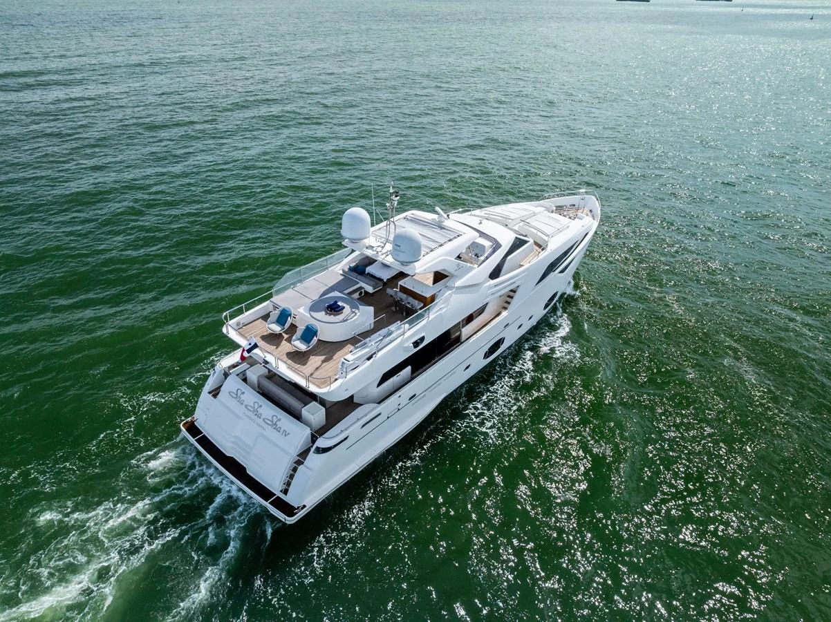 A luxurious yacht cruising through calm waters, showcasing its sleek design and spacious deck areas. aboard SHA SHA SHA IV Yacht for Sale