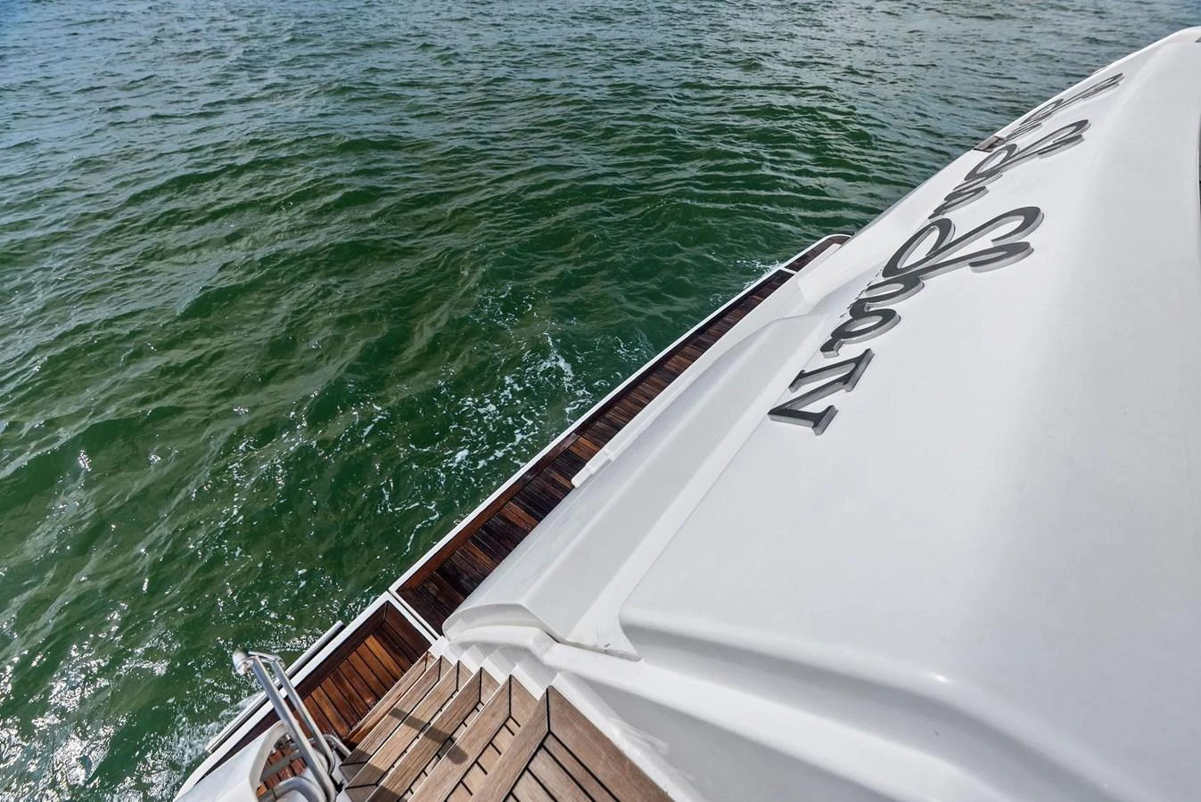 A close-up view of the yacht's stern with teak decking and part of the yacht's name visible. aboard SHA SHA SHA IV Yacht for Sale