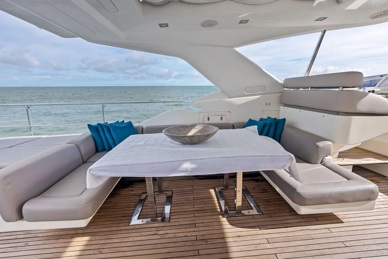 The aft deck features a stylish dining area with comfortable seating and a sleek table, perfect for alfresco meals with a view of the sea. aboard SHA SHA SHA IV Yacht for Sale