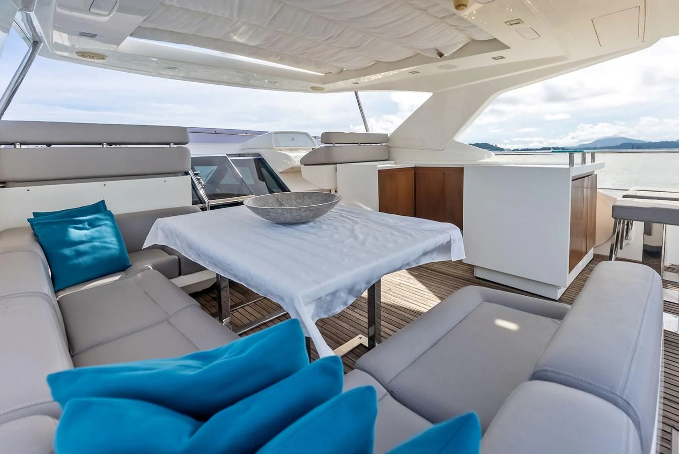 The flybridge features a spacious seating area with a table, perfect for outdoor dining and relaxation. aboard SHA SHA SHA IV Yacht for Sale